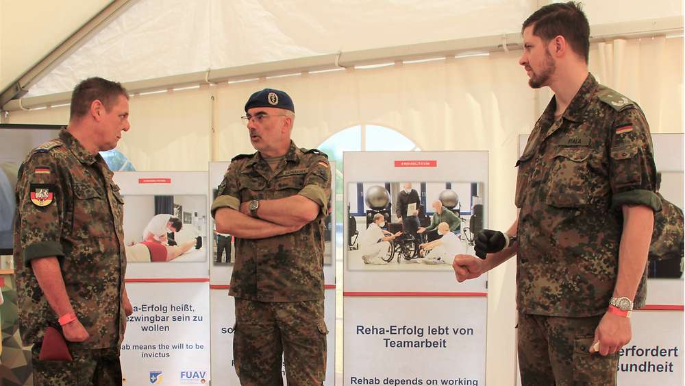 Generaloberstabsarzt Dr. Baumgärtner im Gespräch mit zwei besonders schwer beeinträchtigten Soldaten